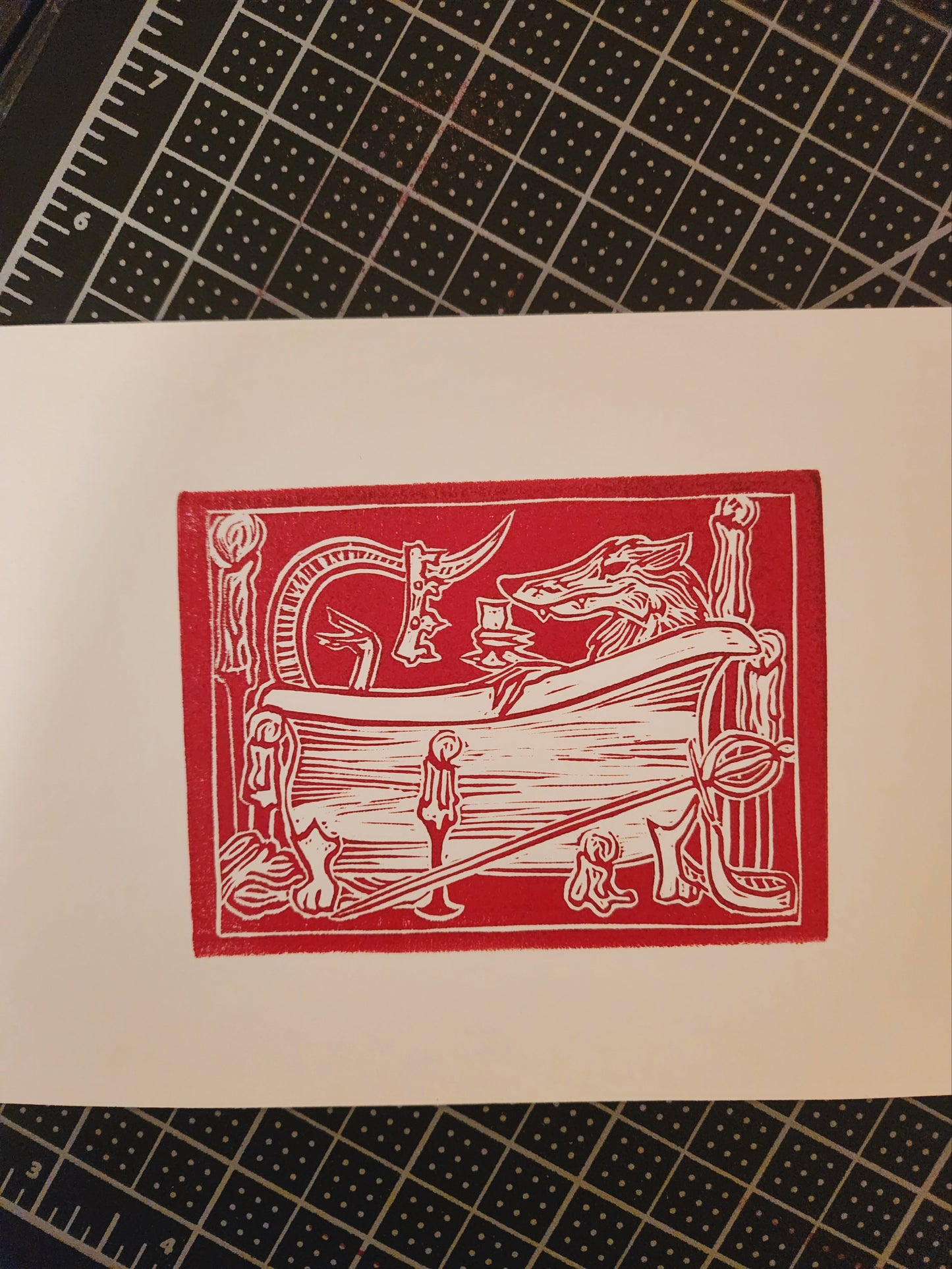 Linocut of a rat in a bathtub with a crown and candles in red ink